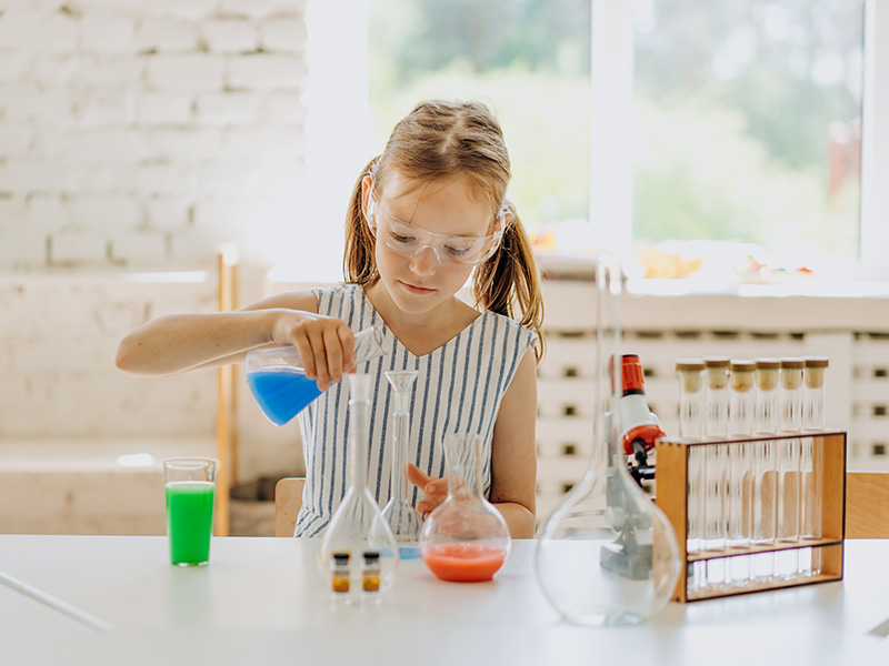 a girl performing a chemistry experiment in a lab