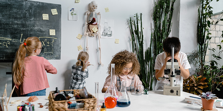 four kids exploring and experimenting in a laboratory classroom