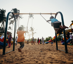 kids sitting on a swing outside